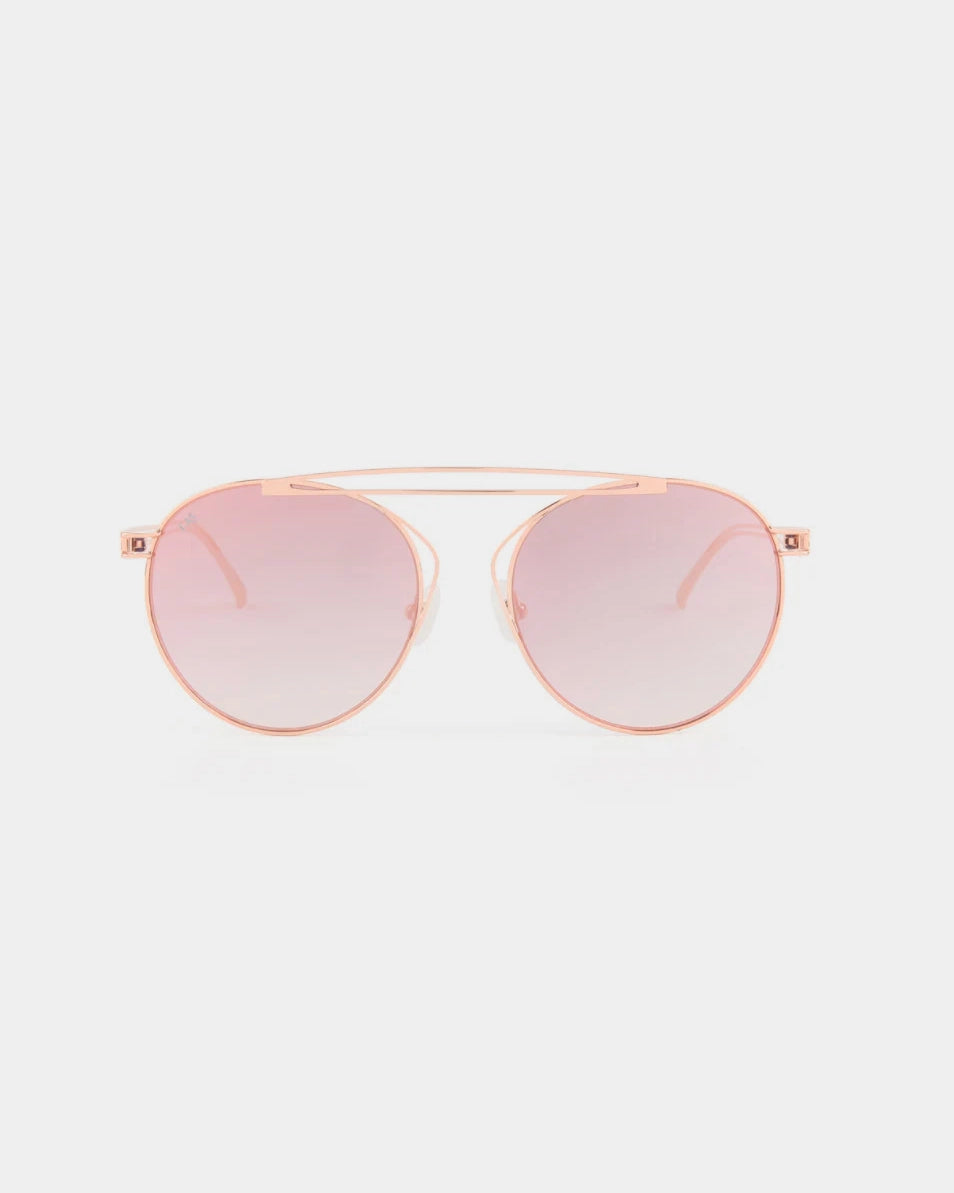 A T-shirt by For Art&#39;s Sake® featuring UV-protected, pink-tinted nylon lenses and a delicate gold stainless steel frame, designed with a double bridge and thin temples for a modern and sleek appearance against a plain white background.