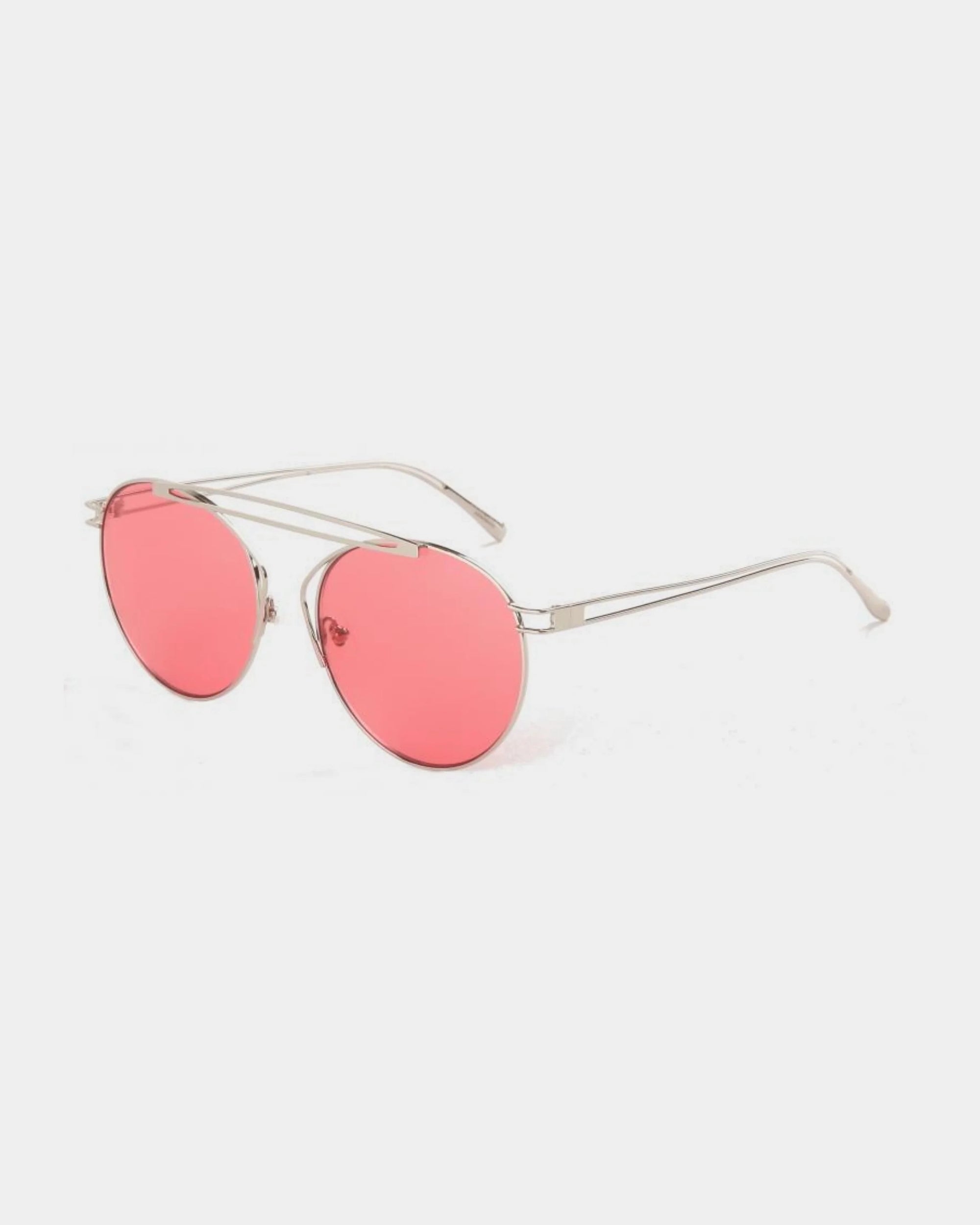 A pair of sunglasses from For Art's Sake® featuring thin, stainless steel frames and round, pink-tinted nylon lenses. The design boasts a minimalistic aesthetic with slender arms and a delicate nose bridge, set against a white background.