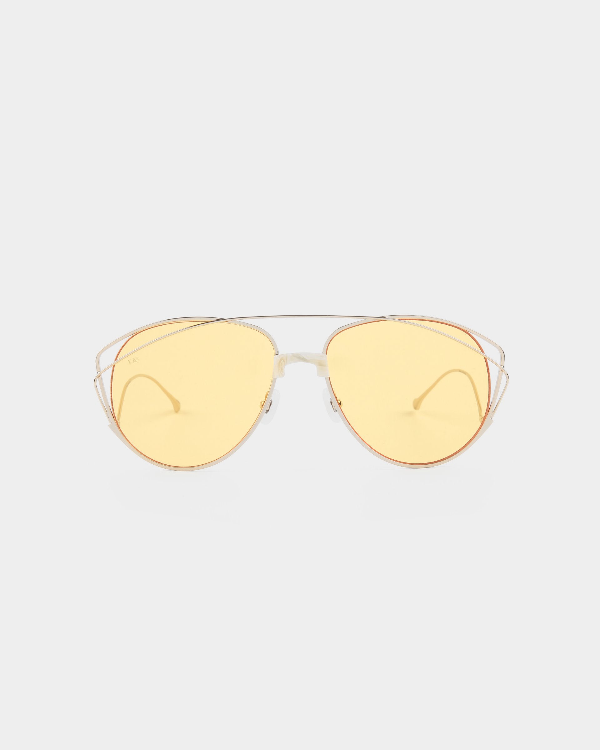 A pair of stylish For Art&#39;s Sake® Dark Eyes sunglasses with thin, stainless steel frames and yellow-tinted, nylon lenses. The design features a double bridge and sleek, minimalistic arms. Offering 100% UV protection, these sunglasses are set against a plain, white background.
