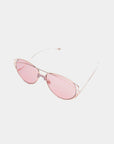 A pair of For Art's Sake® Dark Eyes sunglasses with pink-tinted, nylon lenses and thin, rose gold frames offering 100% UV protection, laid on a white background.