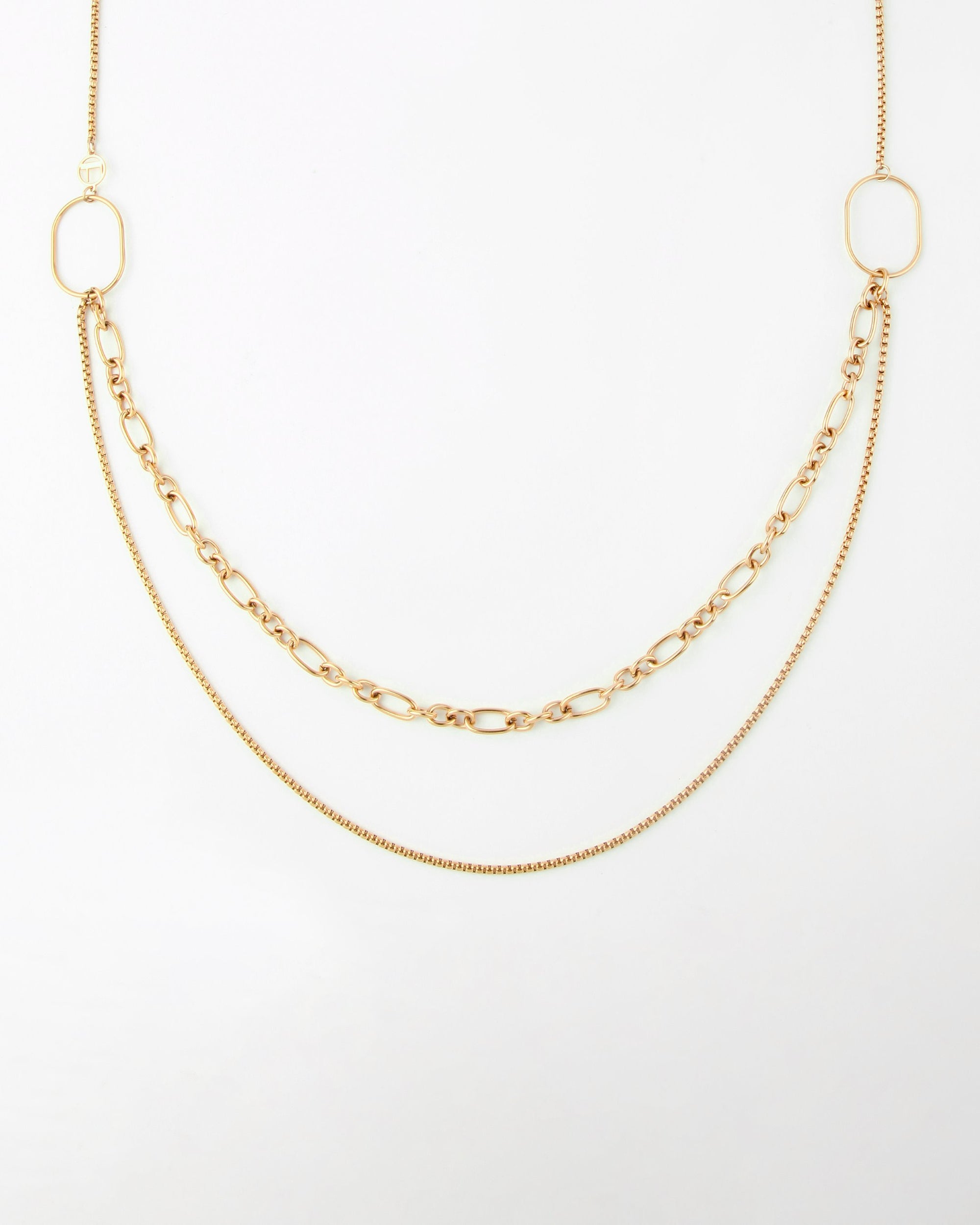 Alba Glasses Chain by For Art's Sake®: Gold necklace with three different chains: one thick oval-linked chain draped in the center and two thinner chains in varying lengths, all connected to two solid oval-shaped loops on either end. This multi-strand necklace is displayed on a plain white background.