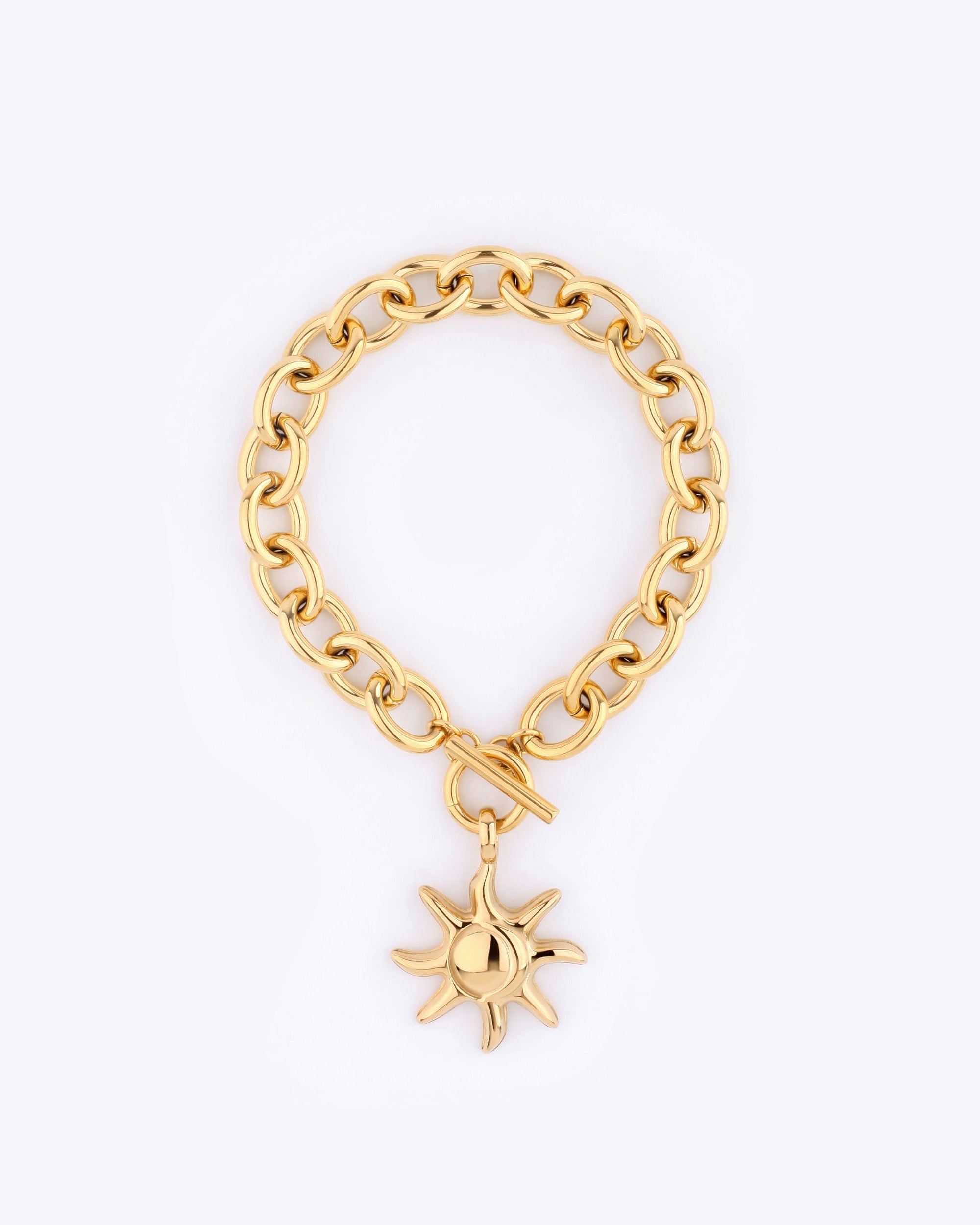 The Crescent Moon Bracelet by For Art's Sake® is a gold chain bracelet measuring 20cm in length, adorned with a sun-shaped charm that has smooth surfaces and raised rays. It is elegantly secured with a toggle clasp and displayed against a light gray background.