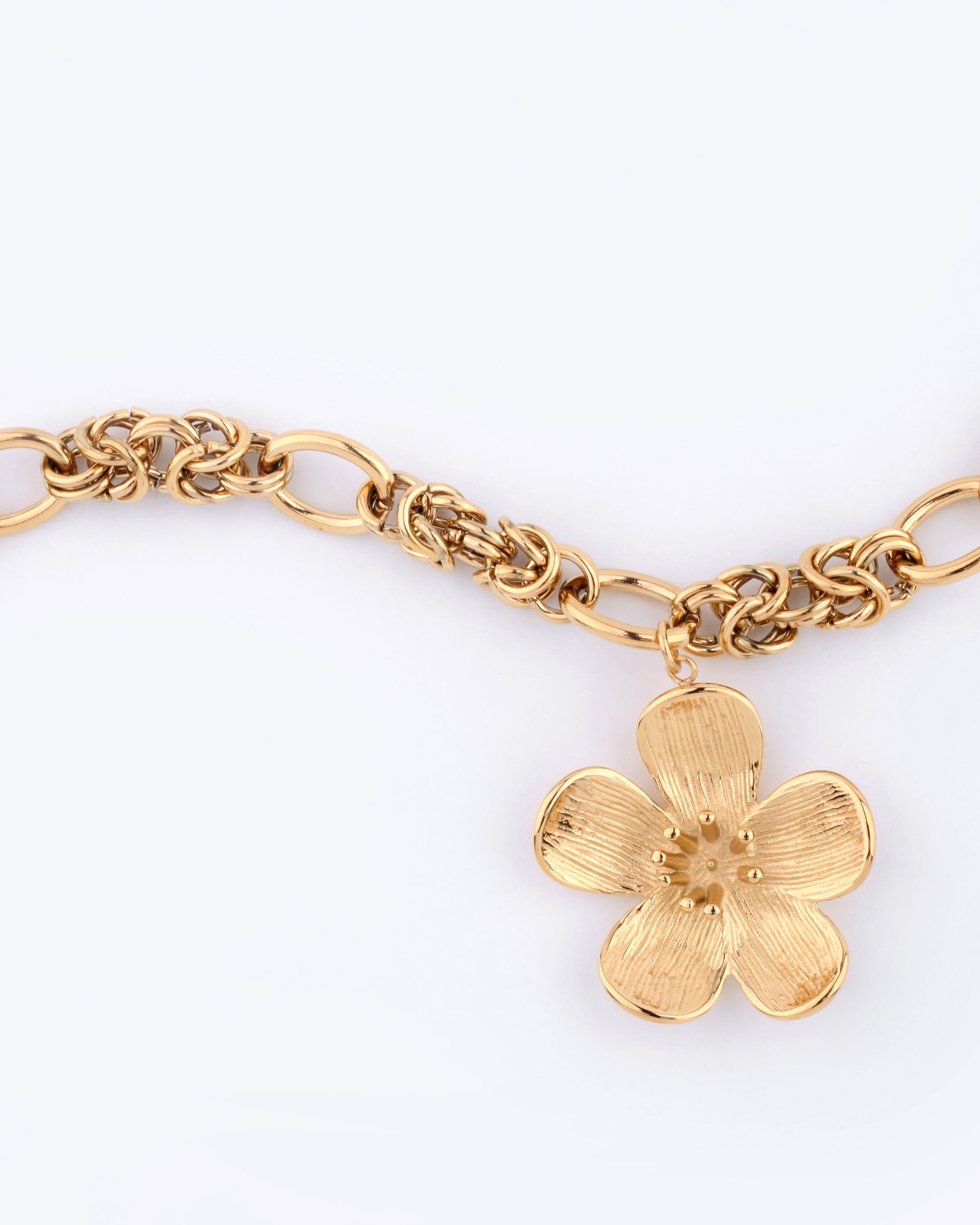 The Blossom Bracelet by For Art&#39;s Sake® elegantly incorporates intricate links, showcasing a flower-shaped pendant with detailed petals against a plain background.