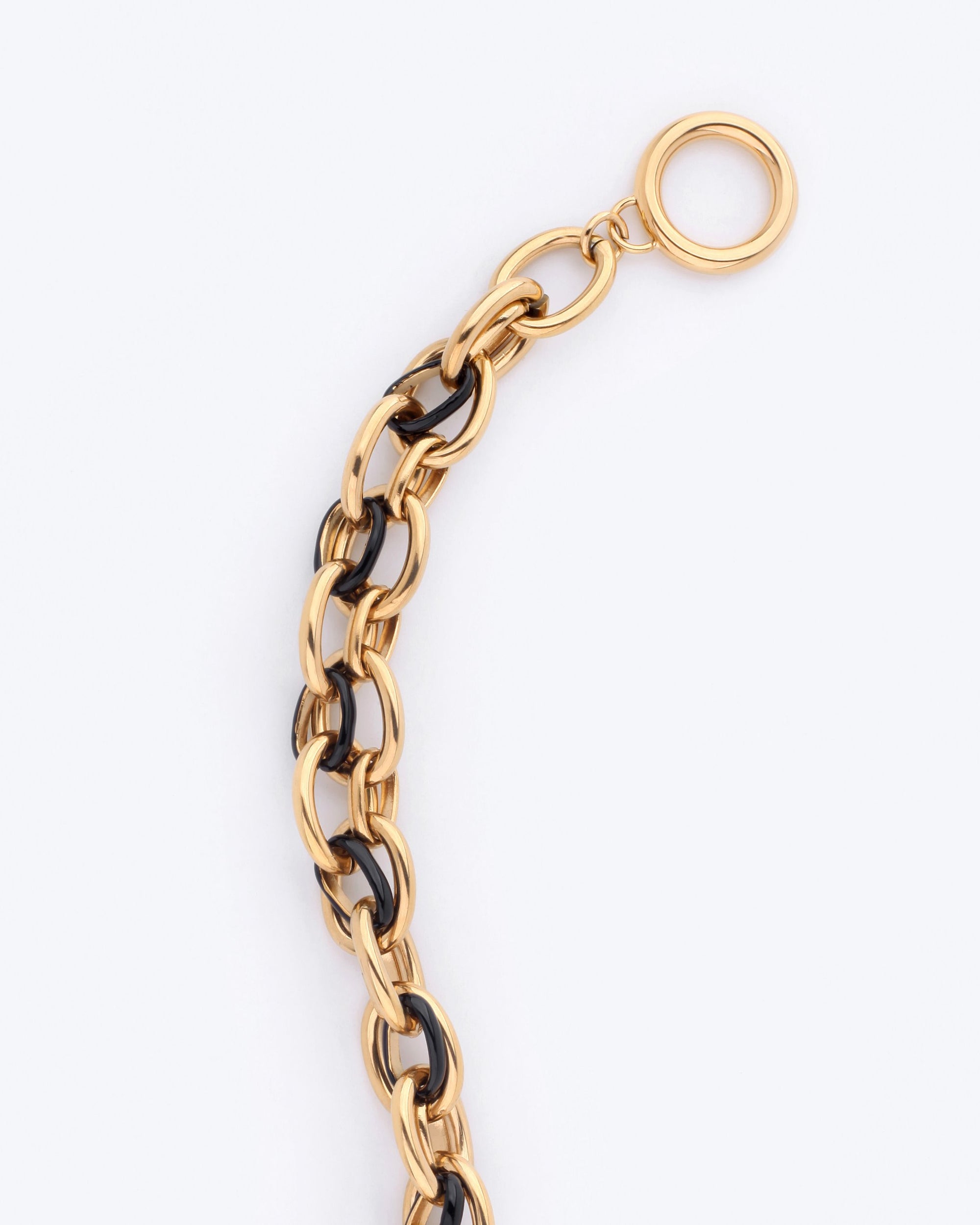 Close-up of the Raya Bracelet by For Art&#39;s Sake®, showcasing its stylish interlocking gold and black links with an elegant circular clasp at one end. The bracelet measures precisely 20.5cm in length and is set against a plain light background.