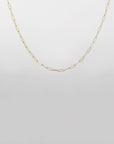 A delicate 18-karat gold-plated chain necklace with oval links is displayed against a plain white background. The simple yet elegant design highlights the thin, interconnected oval-shaped links, creating a minimalist and refined piece of jewelry. This is the Buddha Glasses Chain by For Art's Sake®.