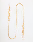 A gold-plating stainless steel chain link necklace with a mix of small and large oval links, featuring delicate pearl accents at each end. The design includes a section of intricate, smaller interlinked chains, creating a sophisticated and elegant appearance on a white background. Introducing the Milan Glasses Chain by For Art's Sake®.