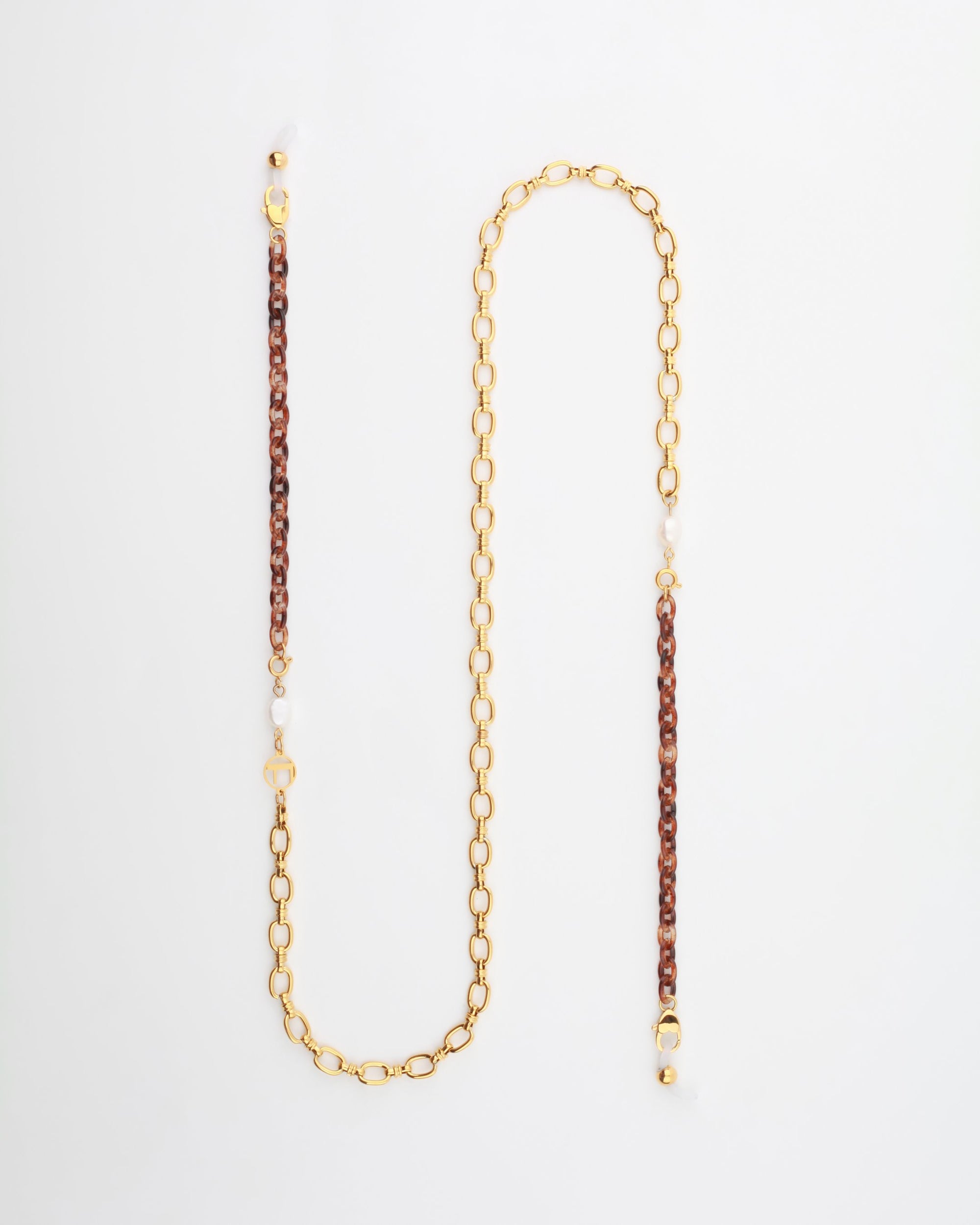 A stylish gold-plated eyewear chain with alternating links of brown braided material and freshwater pearl embellishments evenly spaced along its length, creating an elegant and modern design. The **Tokyo Glasses Chain** by **For Art's Sake®** is laid flat on a white background.