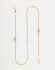 A delicate, 18-karat gold-plated Havana Glasses Chain with small, round beads and toggle clasps. The chain features freshwater pearl charms interspersed along the heart-shaped chain, giving it an elegant and sophisticated look. The design of the Havana Glasses Chain by For Art's Sake® is minimalist and refined.