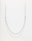 A silver necklace with a unique design featuring two types of chain styles: a thin, delicate chain at the lower level and a thicker, patterned chain on top. Enhanced with 18-karat gold-plating, this layered accessory exudes style and elegance, perfect for pairing with the Vienna Glasses Chain by For Art's Sake®.
