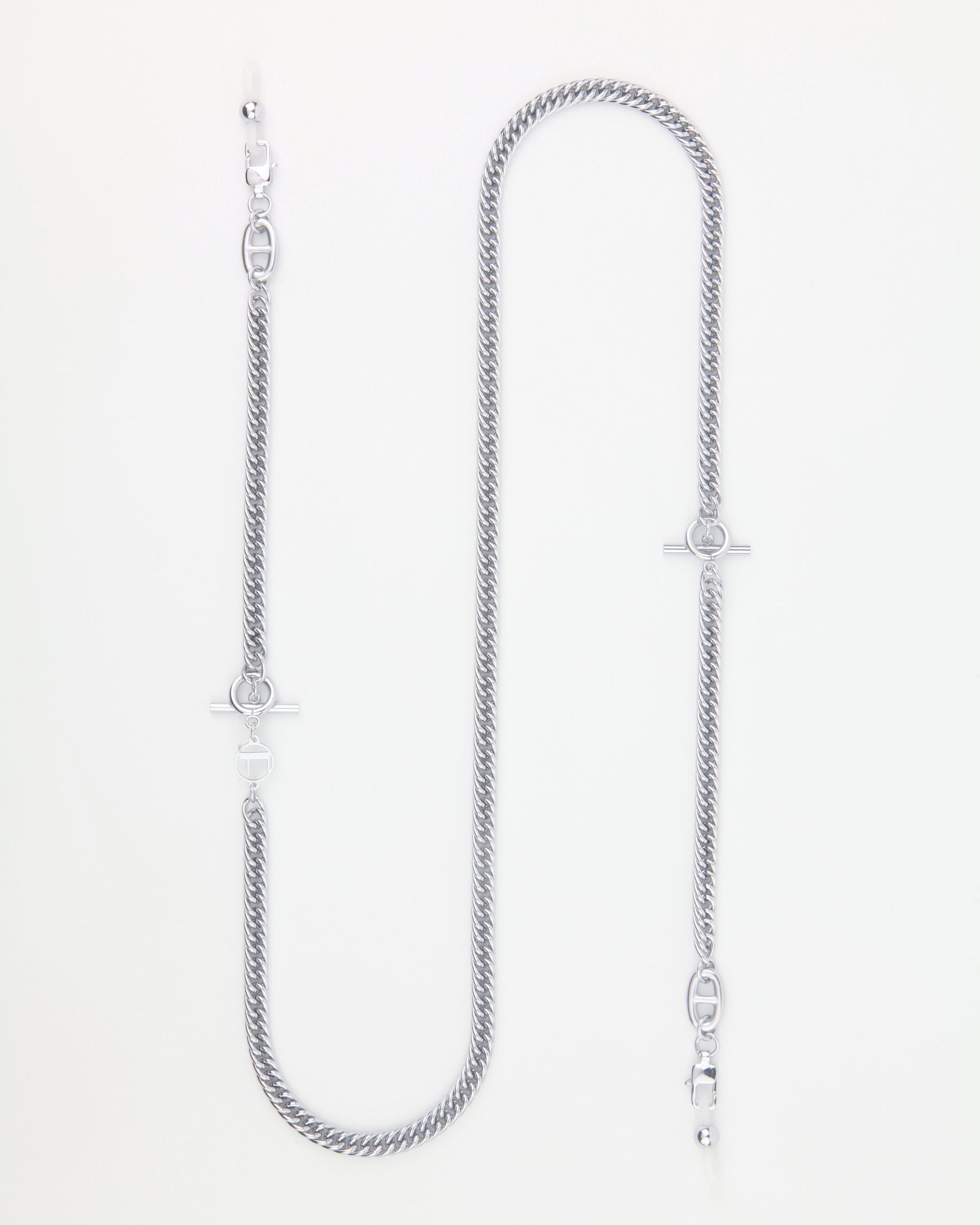 A long, silver chain link necklace with a sleek, twisted design and gold-plating. The Lisbon by For Art's Sake® features clasp and ring closures on both ends, allowing for versatile styling options. Neatly arranged on a plain, white background, this piece can also be used as an elegant eyewear chain.