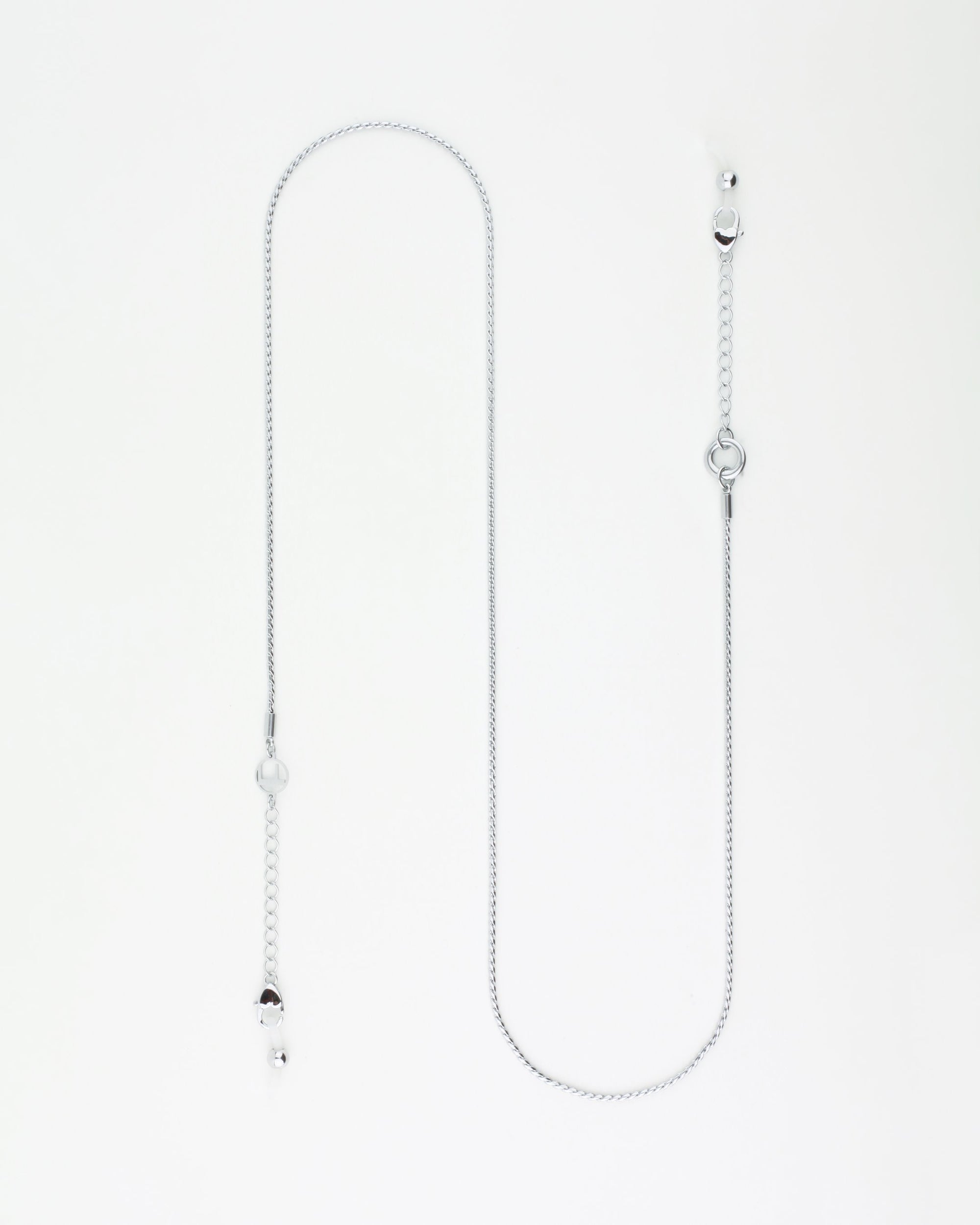 A delicate silver Miami Glasses Chain by For Art's Sake® with palladium-plating is shown on a white background. The chain features a simple design with small clasps at each end for attaching to a face mask. It includes a small round charm as an additional decorative element.