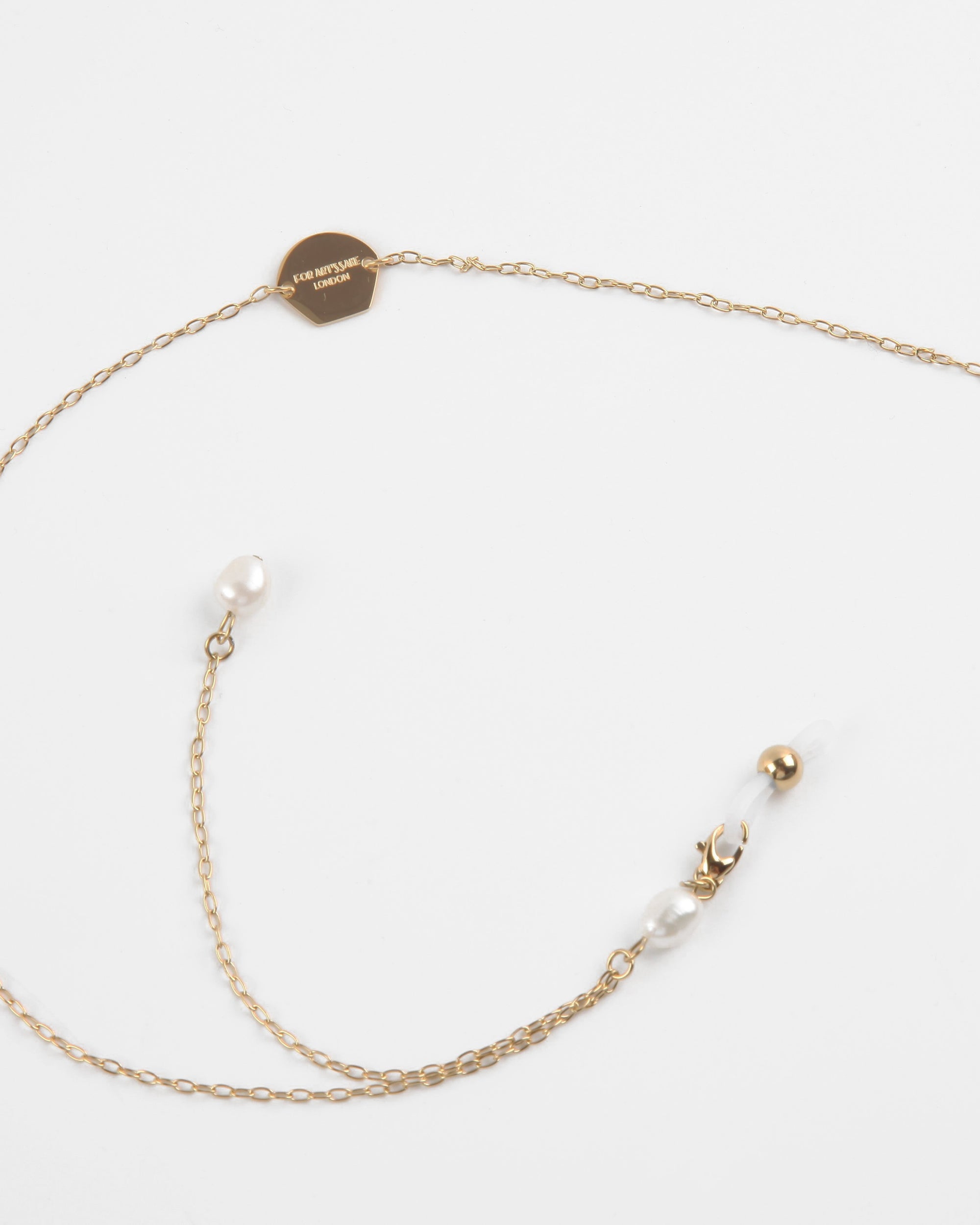 A delicate, lightweight chain in 18K gold features a small round tag inscribed with "Le Pompadour Limited" and is adorned with two freshwater pearl charms. The chain ends with a clasp for fastening, all set against a plain white background. Introducing the **Victoria Glasses Chain by For Art's Sake®**.