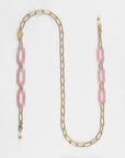 A long gold chain necklace called the Kensington Glasses Chain, made with 18-Karat gold by For Art's Sake®, features a series of rectangular links interspersed with larger, marbled pink and white resin links. The clasp is gold and the chain concludes with a small gold bead detail. The Kensington Glasses Chain is displayed on a white background.