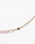 For Art's Sake® Kensington Glasses Chain with two elongated pink marbled links made from Italian acetate. A round 18-Karat gold tag is attached next to the pink links. The background is white.