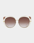 Introducing the Skylar by For Art's Sake®: A pair of stylish round sunglasses featuring gradient brown lenses and elegant gold frames. These frames boast a chic double-bridge design and a rimless bottom half, complemented by brown temple tips. The gradient lenses transition from dark at the top to lighter at the bottom. Don't miss your last chance to snag these sophisticated sunnies!