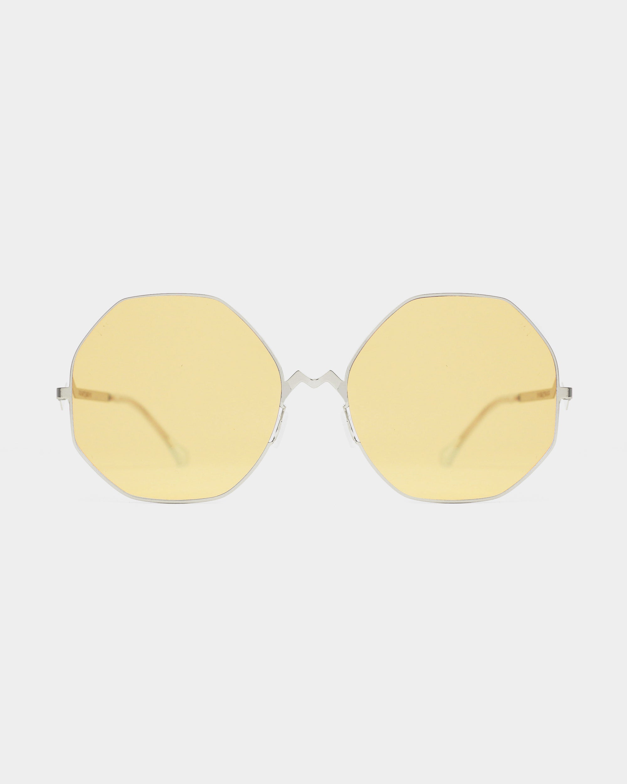 A pair of For Art's Sake® M8 sunglasses, featuring octagonal amber lenses and thin, stainless steel frames, is displayed against a plain white background.