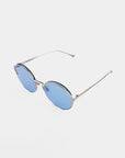 A pair of For Art's Sake® Margarita sunglasses with blue-tinted nylon lenses and thin stainless steel frames and arms, boasting UV protection, set against a plain white background.