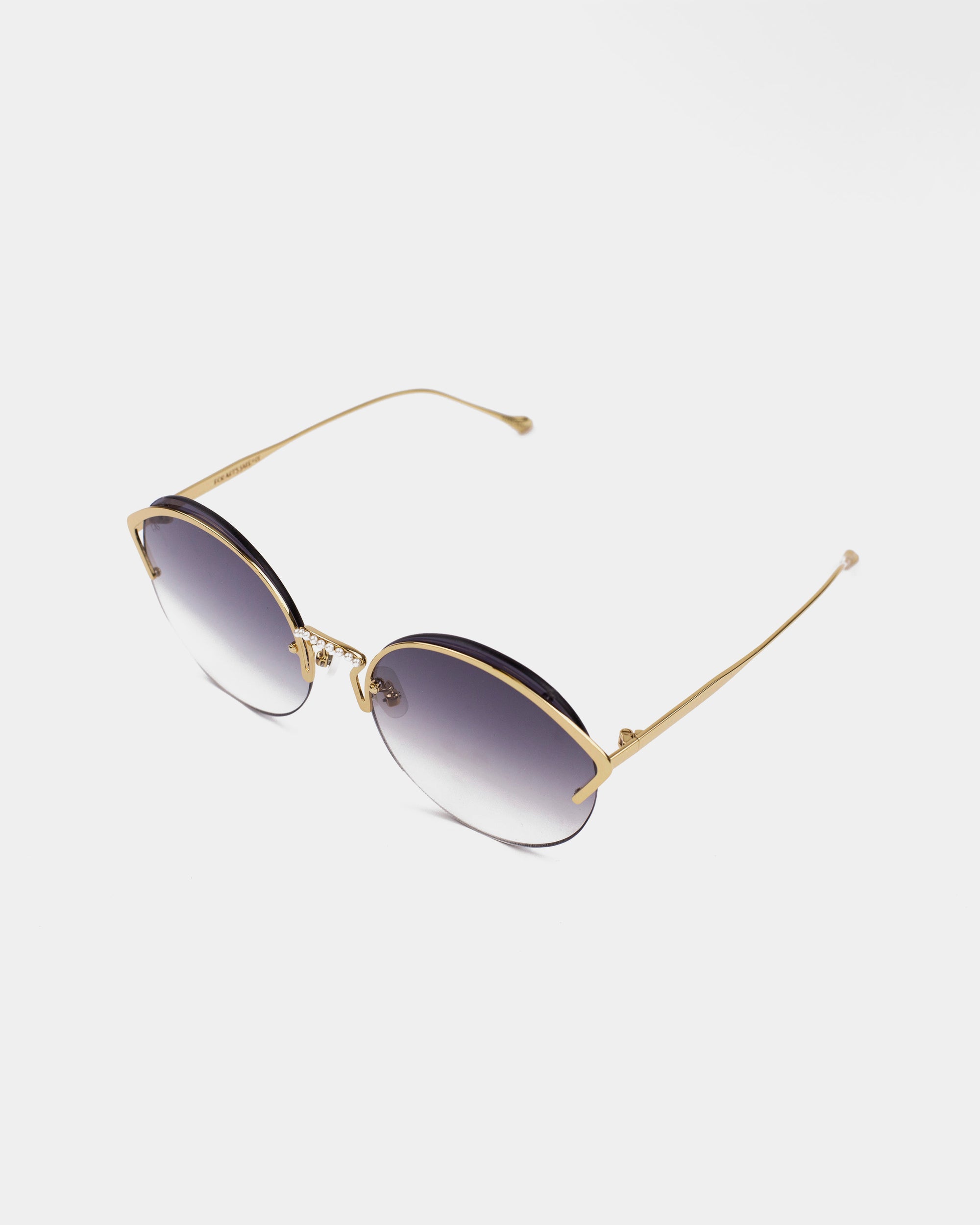 A pair of stylish round sunglasses with gradient nylon lenses and thin gold, stainless steel frames. The glasses are set against a plain white background, showcasing their elegant design, UV protection, and slim metal temples with small end tips. These are the Margarita sunglasses by For Art&#39;s Sake®.