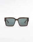 A pair of dark brown, oversized square-framed For Art's Sake® Castle sunglasses with ultra-lightweight green-tinted lenses displayed against a plain white background. The design is modern and sleek, with wide arms for a bold look.