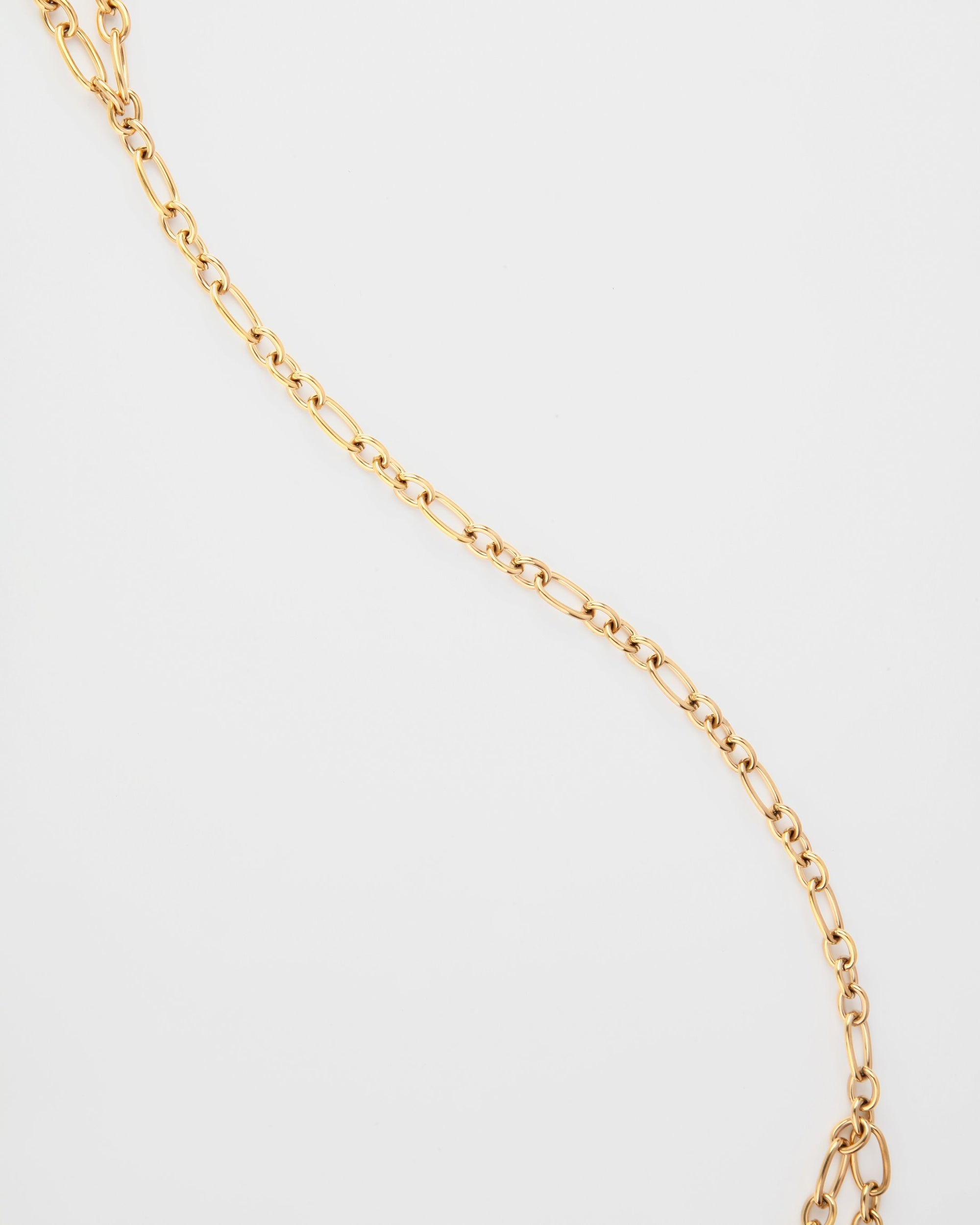 A Clio Glasses Chain by For Art's Sake® with elongated and oval links is arranged diagonally across a plain white background, creating a simple yet elegant appearance, perfect for pairing with layered necklaces.