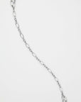 A thin, silver For Art's Sake® Clio Glasses Chain with oval links arranged in an elongated pattern against a plain white background. The chain, perfect for layered necklaces, has a simple and elegant design that reflects light subtly.