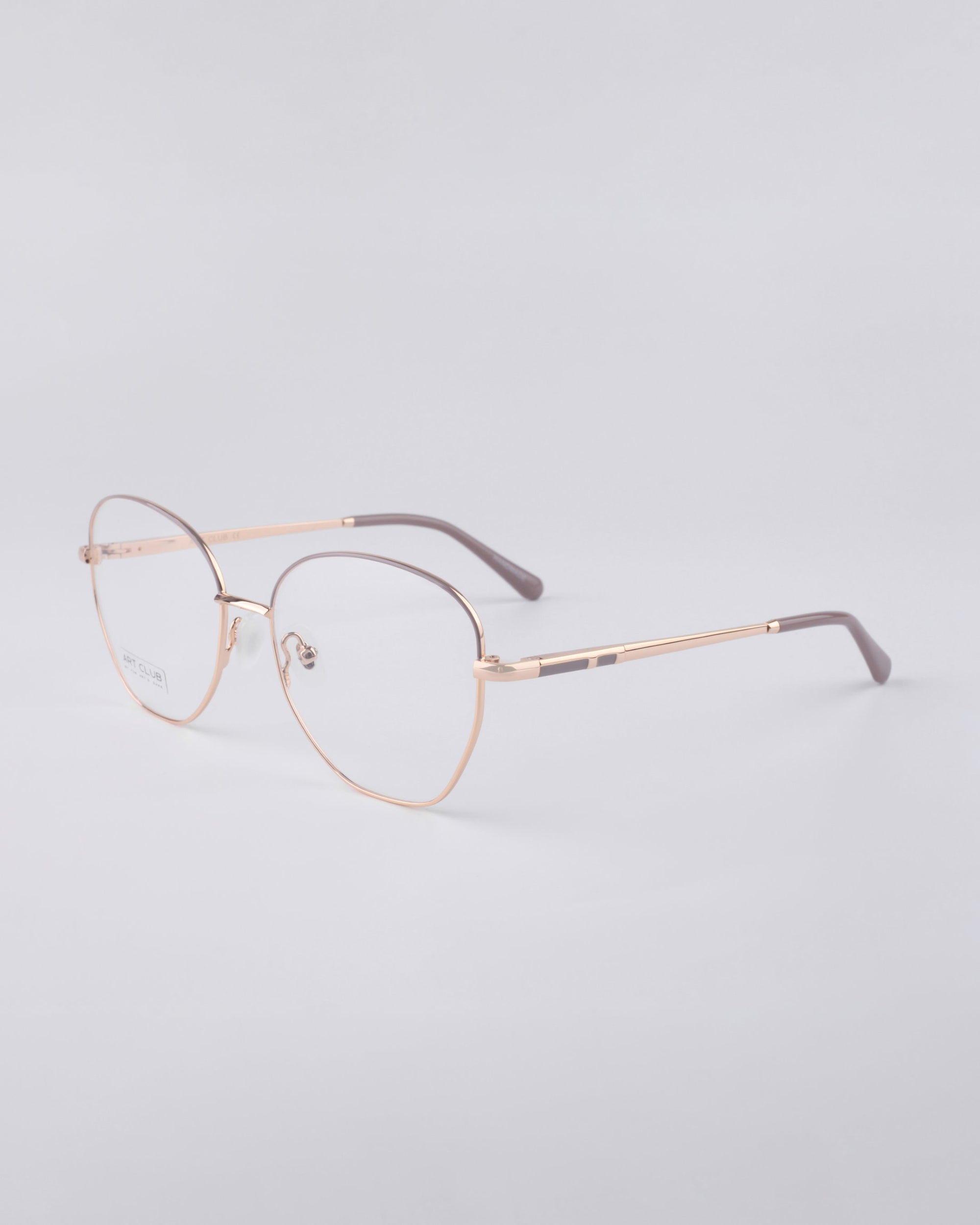 A pair of elegant eyeglasses featuring For Art's Sake® Coco frames in gold metal, complete with blue light filter lenses, set against a light gray background. The glasses include dark-colored tips on the arms.