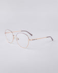 A pair of elegant eyeglasses featuring For Art's Sake® Coco frames in gold metal, complete with blue light filter lenses, set against a light gray background. The glasses include dark-colored tips on the arms.