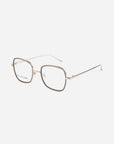 A pair of gold-rimmed, square eyeglasses with thin metal temples, transparent nose pads, and ultra-lightweight lenses featuring a blue light filter. The glasses are set against a plain white background. These are the Coconut by For Art's Sake®.