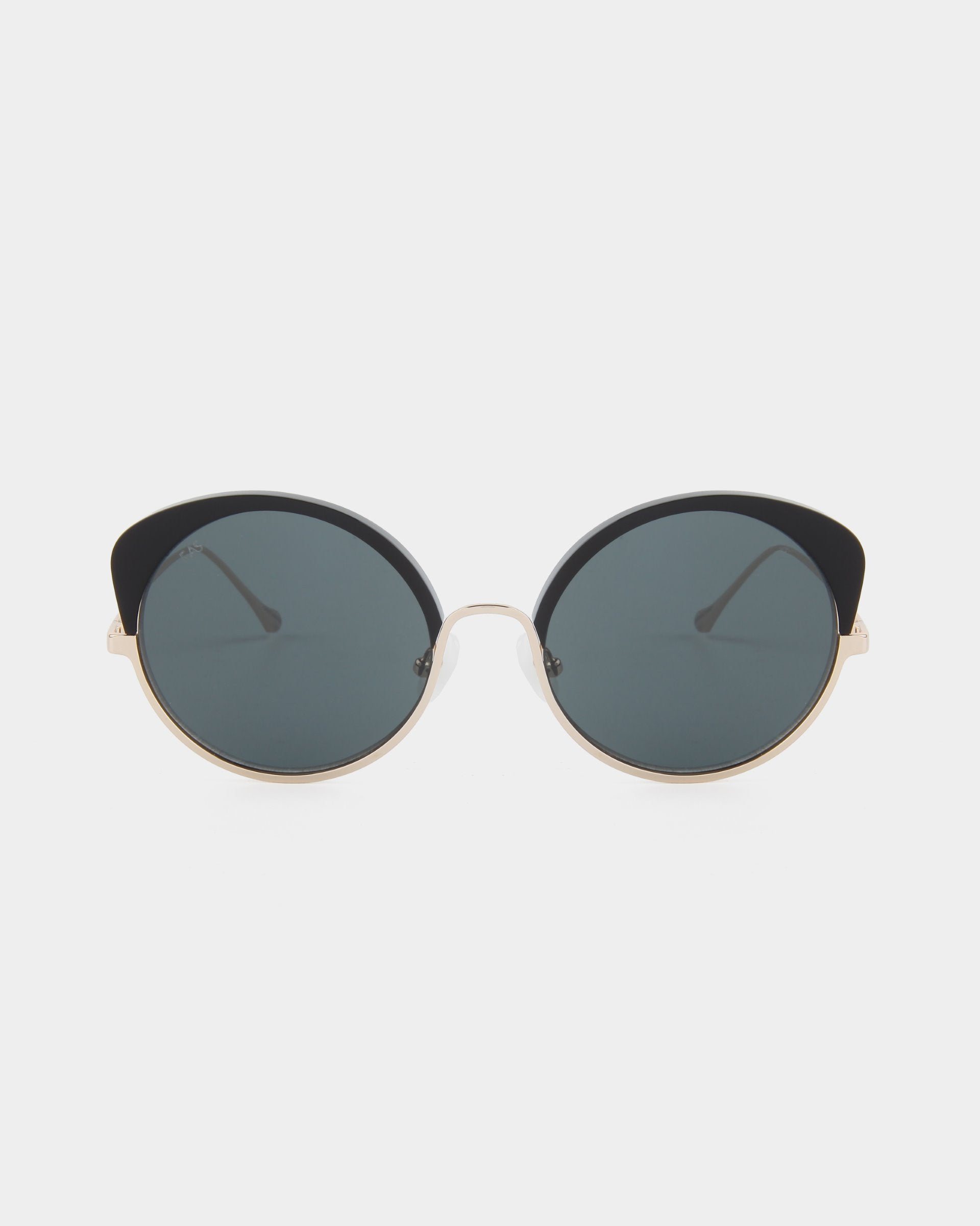 A pair of stylish Cocoon by For Art&#39;s Sake® sunglasses with black frames and dark tinted lenses, set against a plain white background. The temples are thin and metallic, adding to the sleek and modern design. This handcrafted eyewear also offers UV protection, ensuring both elegance and safety.