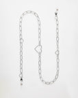 A silver Cupid Glasses Chain by For Art's Sake® with large oval links and statement hearts. The chain features a lobster clasp adorned with additional small charms, including a black bead and a pearl-like bead, attached at various points. Displayed on a plain white background, it exudes elegance and charm.