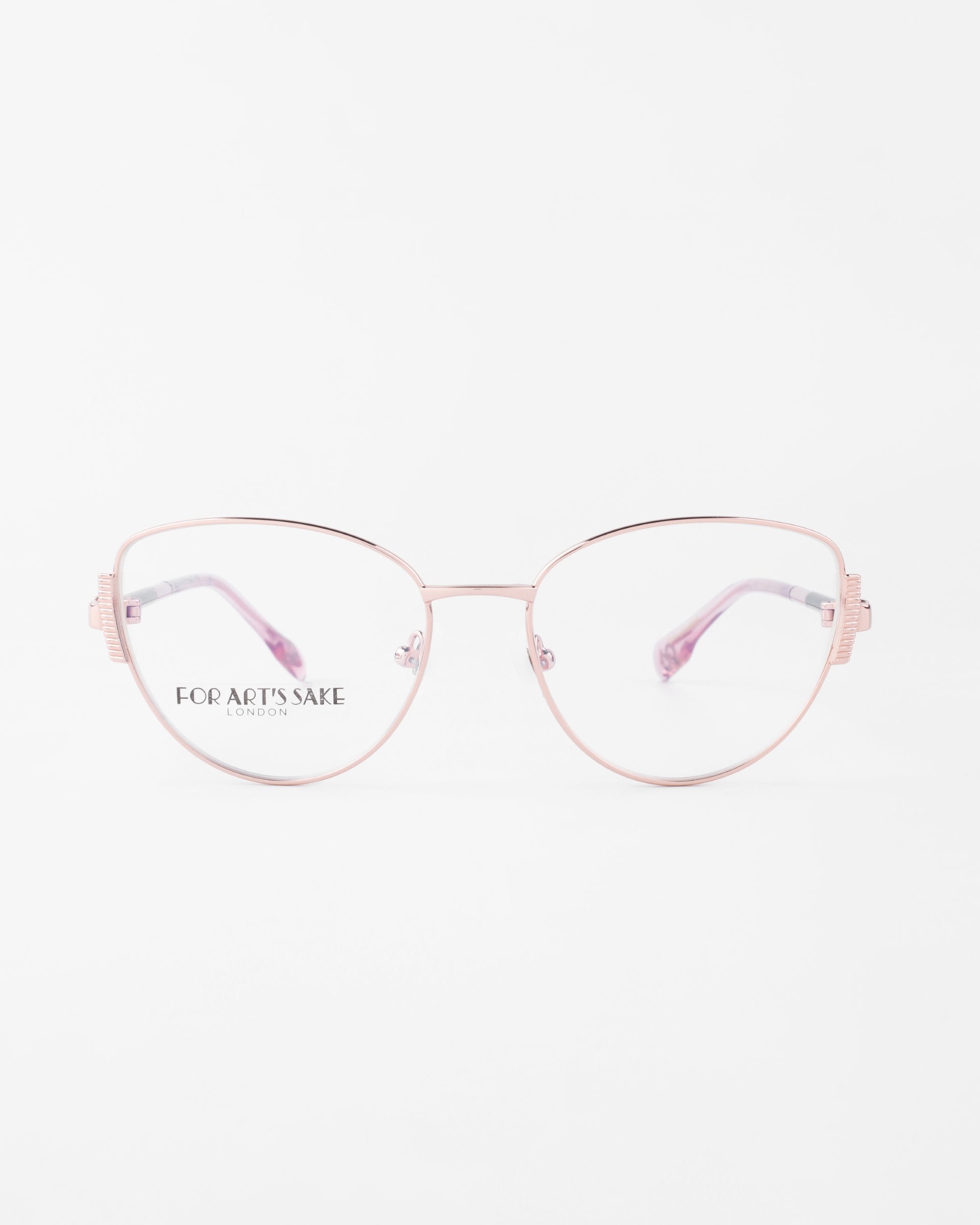 A pair of stylish, cat-eye glasses with thin, light pink metal frames and clear lenses. The brand &quot;For Art&#39;s Sake®&quot; is visible on the left lens. Featuring jade stone nose pads for added comfort, the background is white to highlight the delicate design and intricate detailing of the Dante glasses.