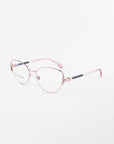 A pair of For Art's Sake® Dante eyeglasses with thin, rose gold metallic frames and clear prescription lenses. The temple arms are rose gold with black accents near the hinges, and the transparent nose pads include a blue light filter. The eyeglasses are set against a plain white background.