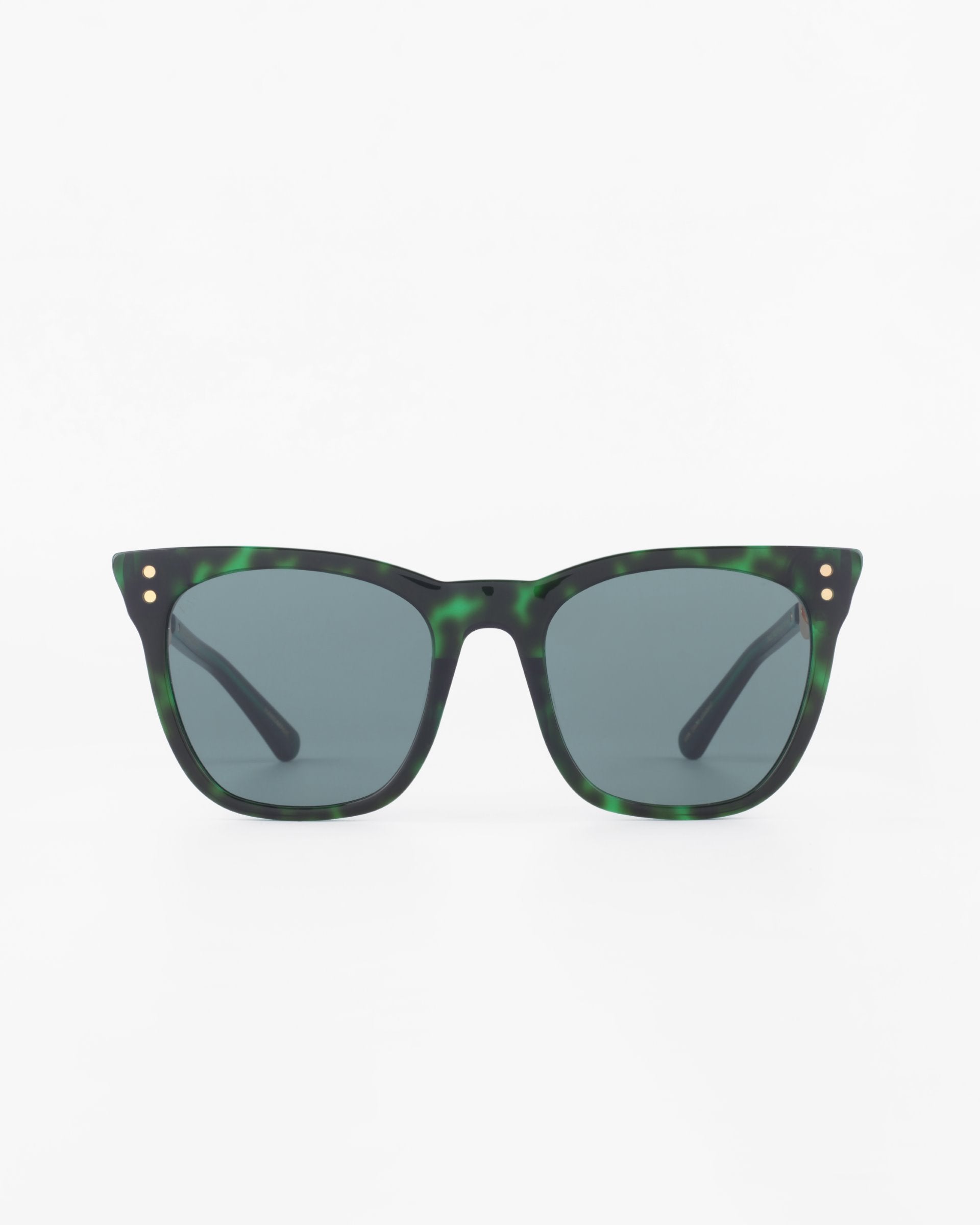 A pair of green tortoiseshell-patterned Deco sunglasses by For Art&#39;s Sake® with a square frame and dark lenses is centered against a plain white background. The acetate temples have small gold accents near the hinges.