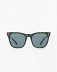 A pair of green tortoiseshell-patterned Deco sunglasses by For Art's Sake® with a square frame and dark lenses is centered against a plain white background. The acetate temples have small gold accents near the hinges.