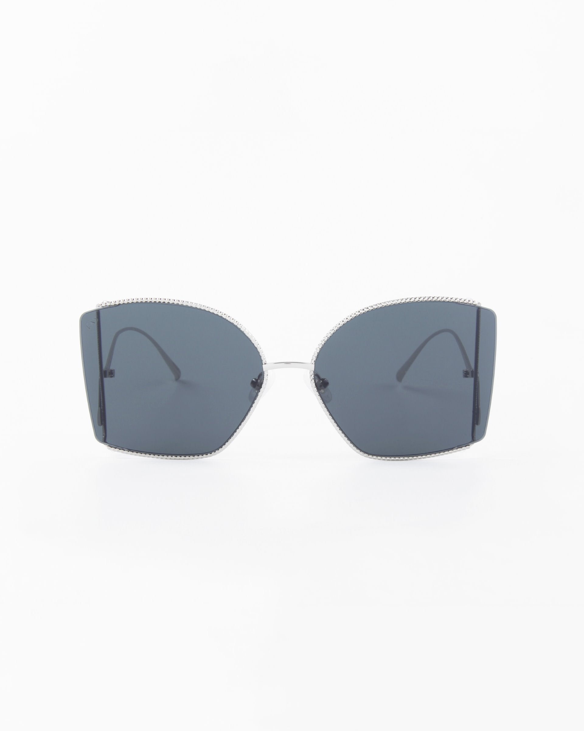 A pair of Dixie sunglasses by For Art&#39;s Sake® with large, angular, dark lenses and thin, handmade gold-plated frames. The design is simple yet stylish, with a modern minimalist appearance. The background is plain white, emphasizing the sleek design of the Dixie sunglasses.