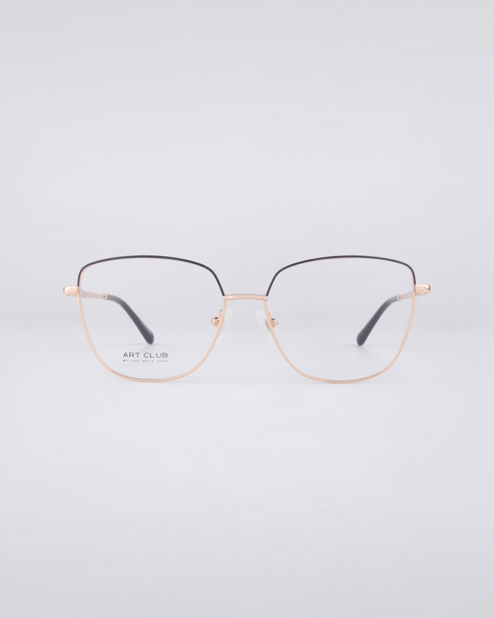 A pair of stylish eyeglasses with a minimalist design features For Art's Sake® Dora frames and a stainless steel core. The black frame is accented with gold and showcases a subtle geometric shape. These glasses, equipped with blue light filter lenses, are centered against a simple, light grey background.