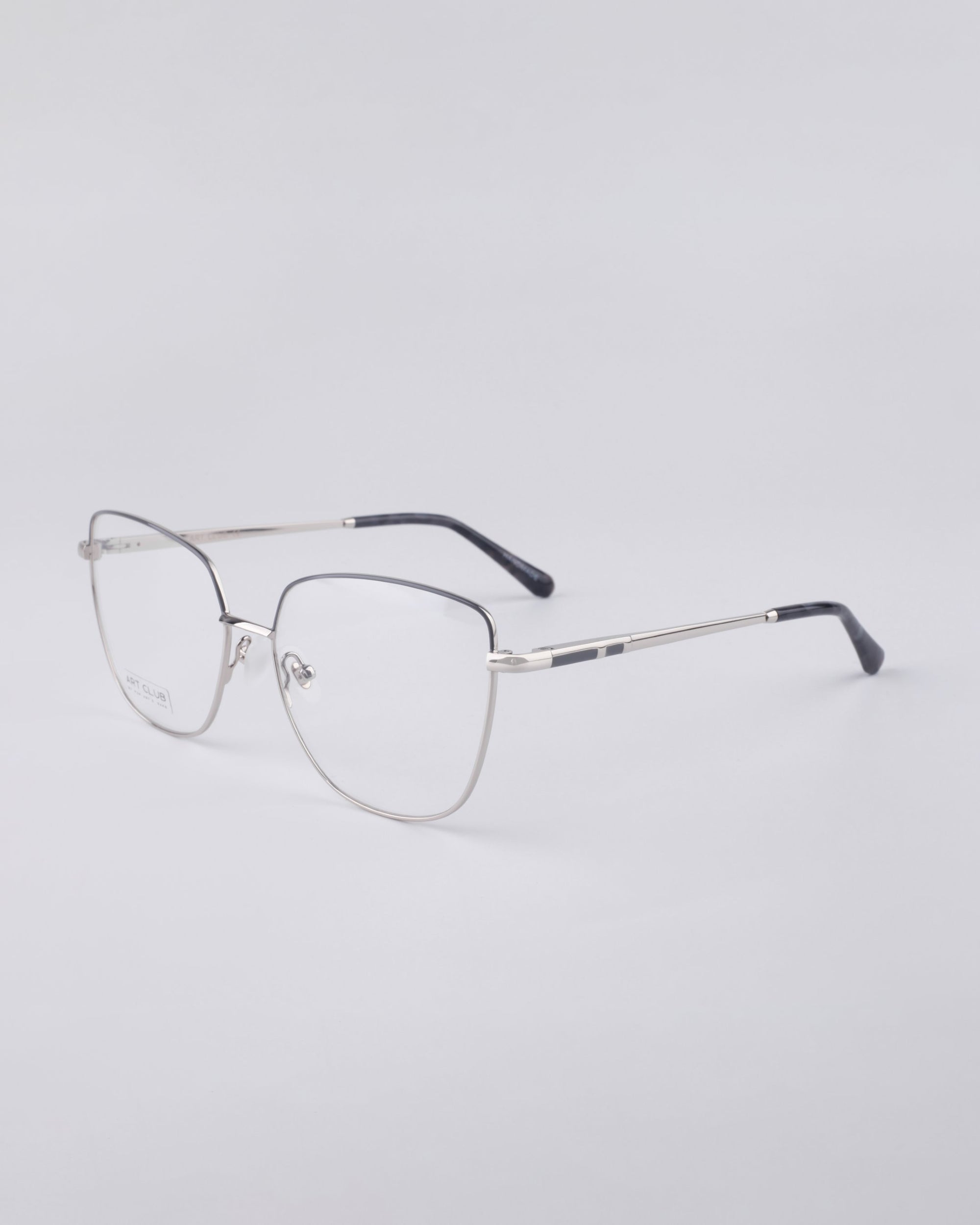 Displayed against a light gray background, the elegant Dora frames by For Art's Sake® are crafted with a stainless steel core. These eyeglasses feature a thin wire-frame design with rectangular lenses and black temple tips.