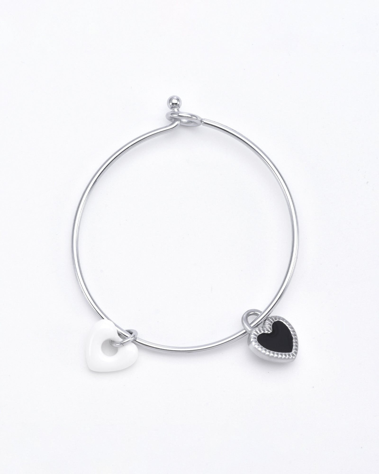 Simple silver bracelet with two heart-shaped charms: one white and one black with a silver outline. This elegant Double Heart Bracelet Silver by For Art's Sake® features a small clasp and is displayed against a white background.