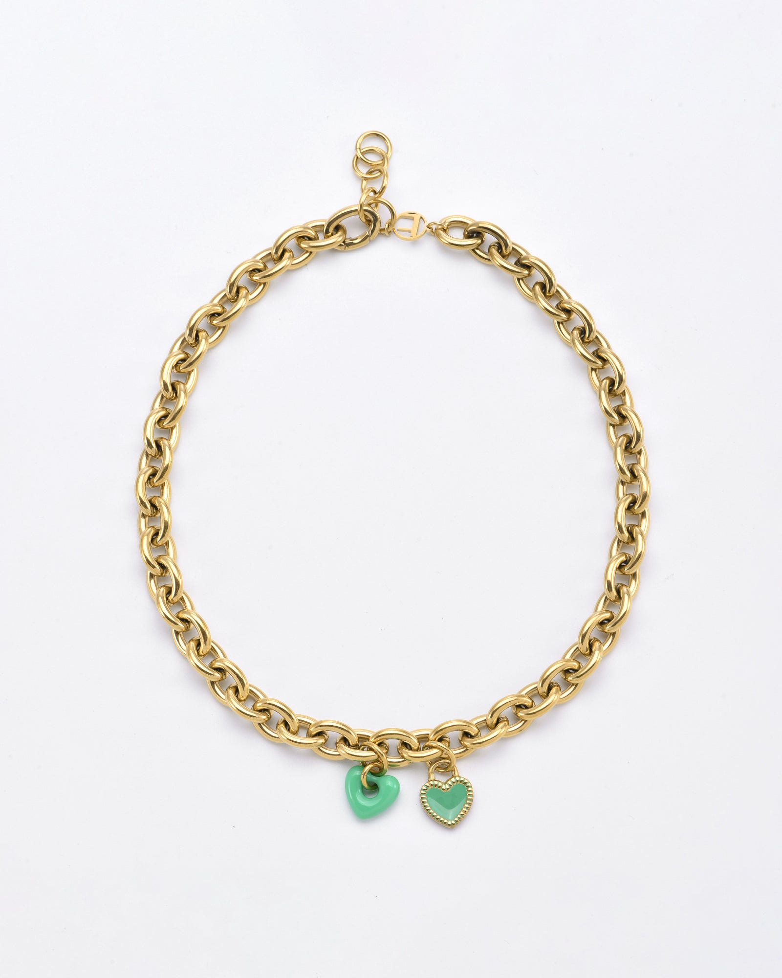 A For Art&#39;s Sake® Double Heart Necklace Gold featuring double hearts; one is a solid green charm and the other is a green outlined heart encrusted with small stones. The necklace has a lobster clasp closure.