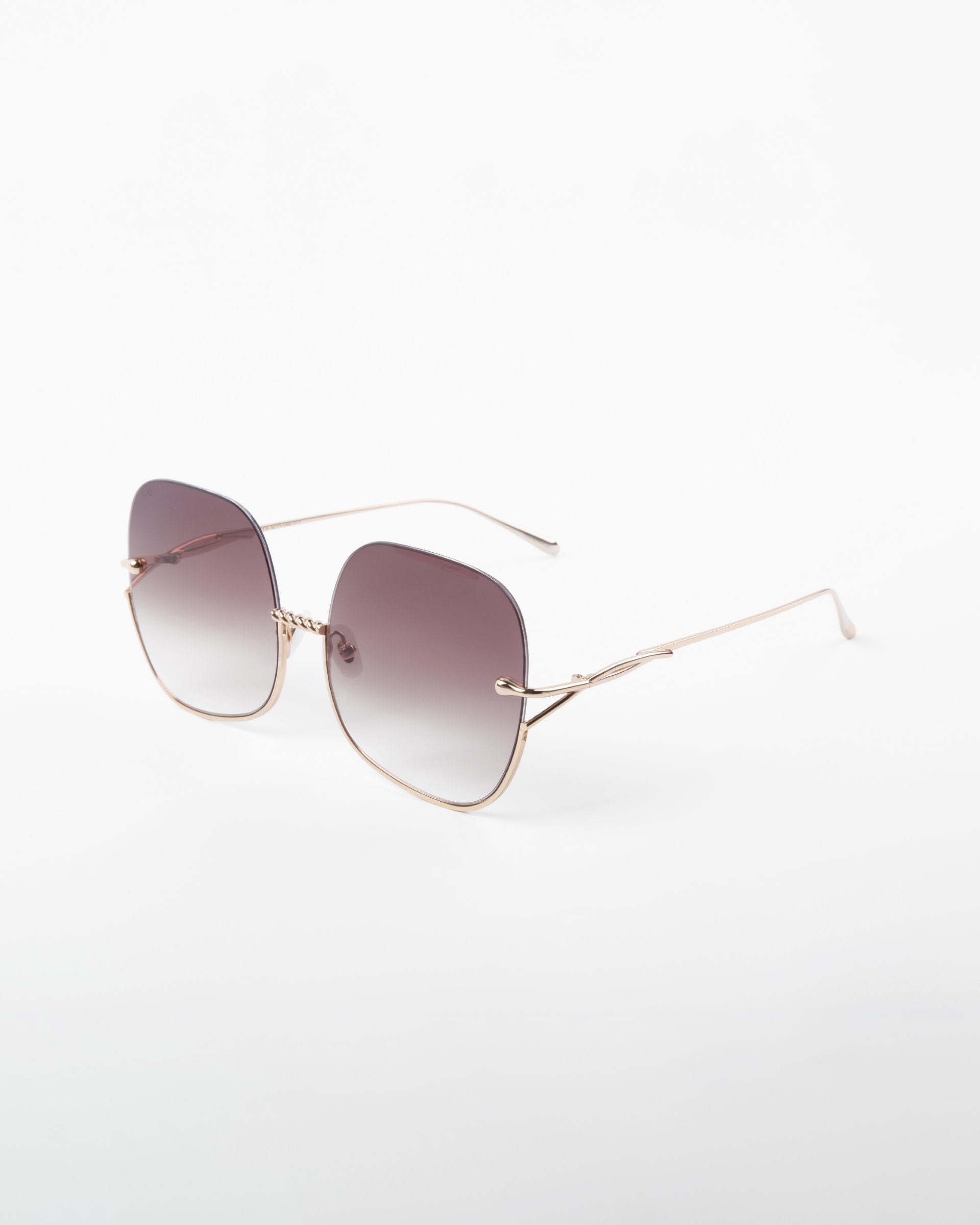 A pair of square-shaped Duchess sunglasses by For Art&#39;s Sake® boasting a handmade gold-plated frame and shatter-resistant, gradient lenses. The lenses transition from dark at the top to lighter shades toward the bottom, offering full UVA &amp; UVB protection. The Duchess sunglasses by For Art&#39;s Sake® are positioned on a plain white background.