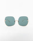 A pair of stylish Duchess sunglasses from For Art's Sake® with large, square-shaped, shatter-resistant lenses tinted in a cool blue color. The frame is minimalistic with thin, gold-colored arms and a delicate twisted bridge. With UVA & UVB protection, the handmade gold-plated frame stands out against the plain white background, emphasizing the design.