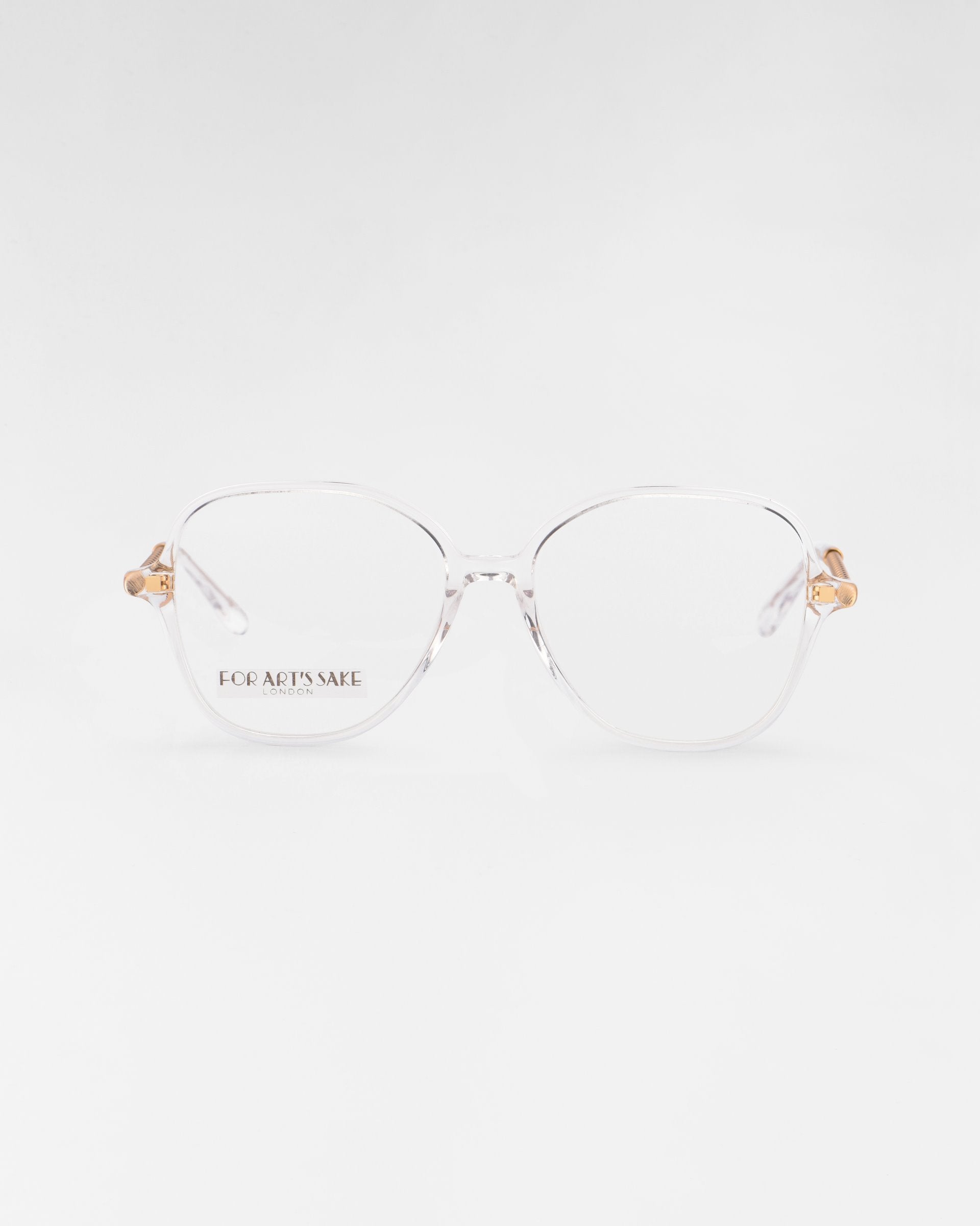 A pair of transparent eyeglasses with a slight hexagonal shape and gold accents on the temples, featuring a blue light filter for added eye comfort. The Dumpling glasses are displayed against a plain white background, with the brand For Art&#39;s Sake® visible on the left lens.