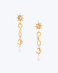 The Sloane Earrings by For Art's Sake® showcase a sun design adorned with a central gem, leading into a twisting structure that culminates in a crescent moon. Each elegant earring features a small pearl dangling at the end, set against a light background for added aesthetic appeal and optimal weight balance, ensuring comfortable wear.