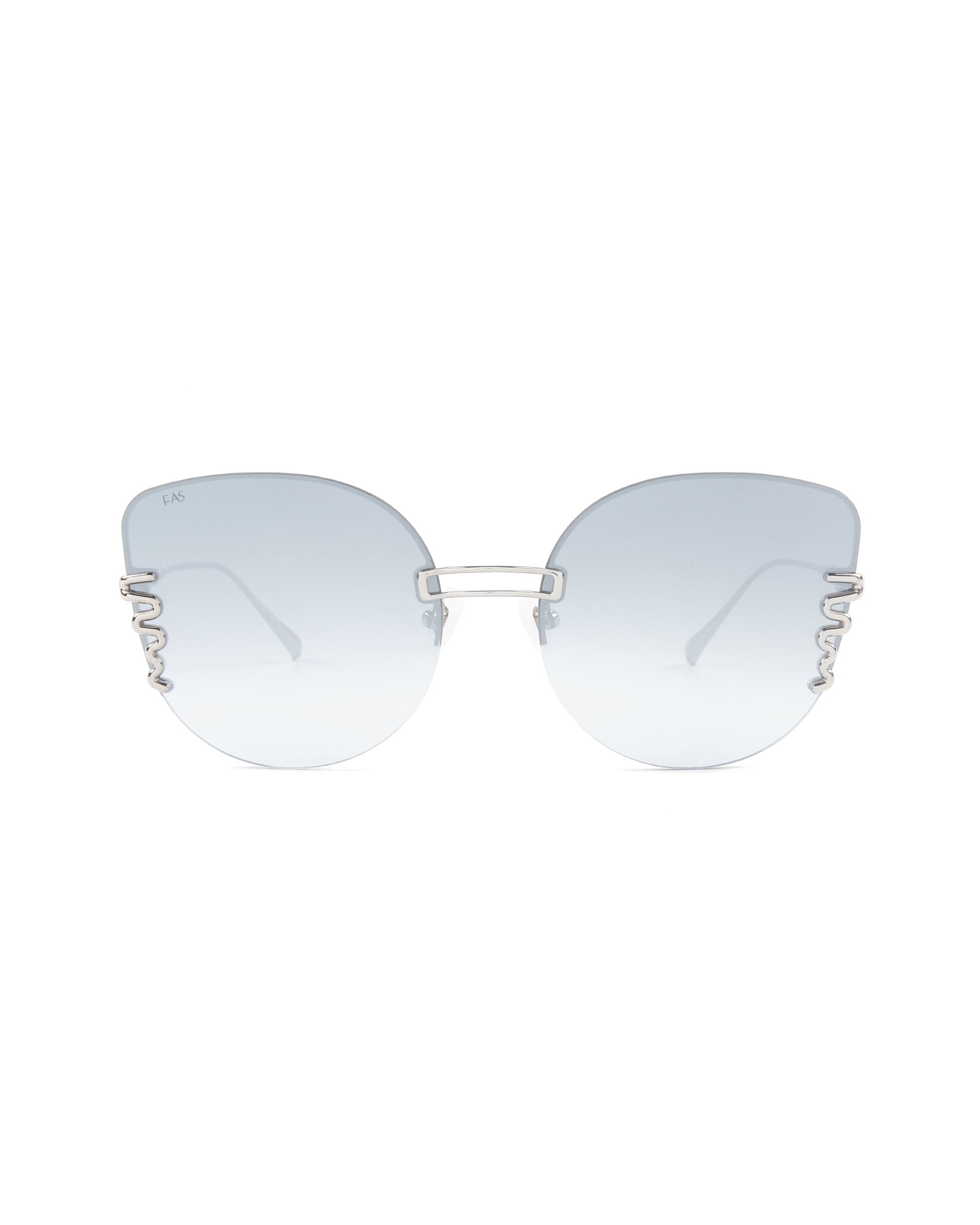 A pair of stylish oversized cat-eye sunglasses with large, lightly tinted blue lenses and a silver metal frame. The temples feature a delicate and intricate cut-out design. The overall look is modern and elegant, complemented by adjustable nosepads for a comfortable fit. Introducing Girlboss by For Art's Sake®.
