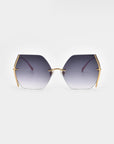 A pair of hexagonal sunglasses with UV protection and gradient lenses that transition from dark to light, set in a gold-plated stainless steel frame with visible jadestone nosepads and temples. The background is plain white, highlighting the sleek, modern design of the Generation sunglasses by For Art's Sake®.