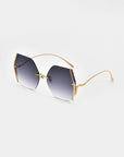 A pair of stylish sunglasses featuring gradient dark lenses and thin, gold-plated stainless steel frames. Enhanced with jadestone nosepads, these Generation sunglasses by For Art's Sake® have a modern, geometric design with a sleek and minimalistic appearance. They offer excellent UV protection and are set against a plain white background.