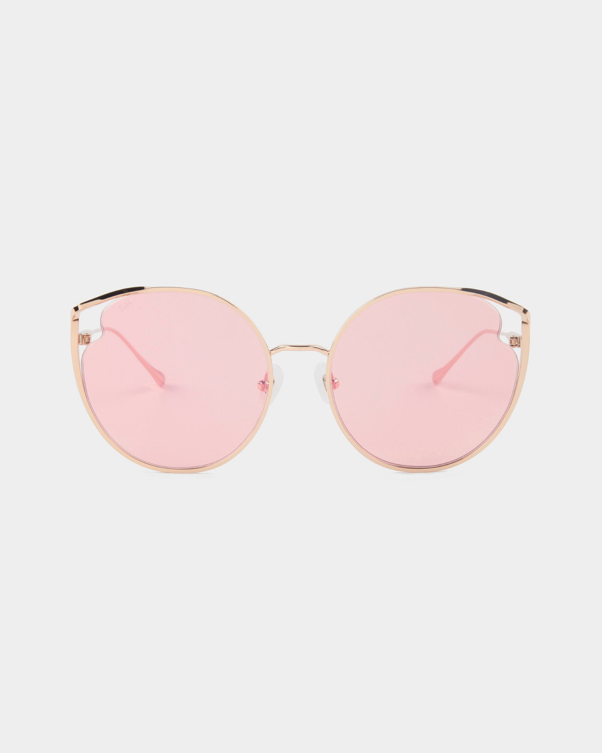 For Art's Sake® "Cat" sunglasses feature gold frames with large, round pink nylon lenses that offer UVA and UVB protection. The minimalist design includes thin metal arms and adjustable nose pads, while the lenses provide a soft, rosy tint.