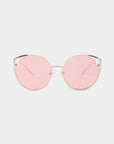 For Art's Sake® "Cat" sunglasses feature gold frames with large, round pink nylon lenses that offer UVA and UVB protection. The minimalist design includes thin metal arms and adjustable nose pads, while the lenses provide a soft, rosy tint.