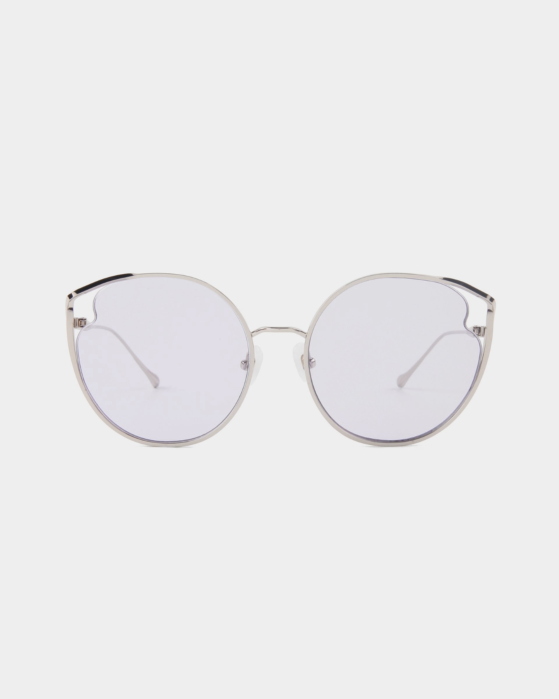 A pair of round, silver-framed eyeglasses from For Art's Sake®'s Cat collection with clear nylon lenses. The frame is thin and minimalist in design, offering a modern, sleek look. Featuring adjustable nose pads for comfort and UVA & UVB protection, the glasses are set against a plain white background.