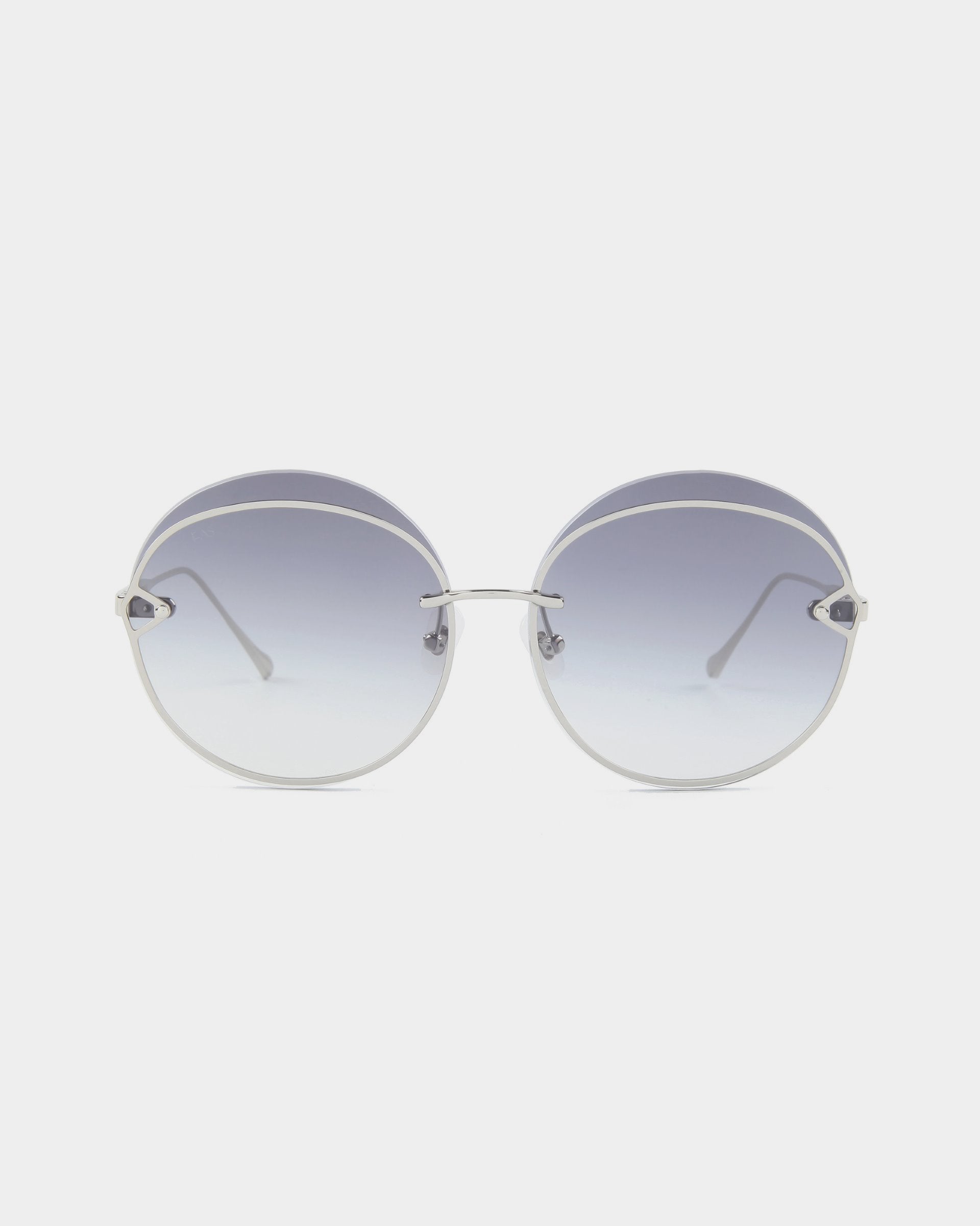 The Quartz sunglasses by For Art&#39;s Sake® feature round stainless steel frames and gradient nylon lenses that transition from dark gray at the top to clear at the bottom. The minimalist design is complemented by metal detailing, UVB-protected lenses, and comfortable nose pads.